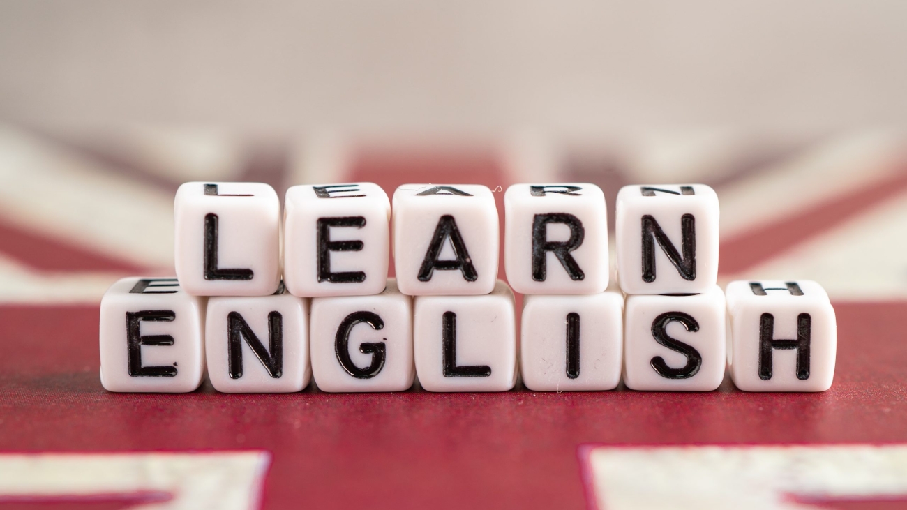 Word Learn English on book with United Kingdom flag, learning English language courses concept.