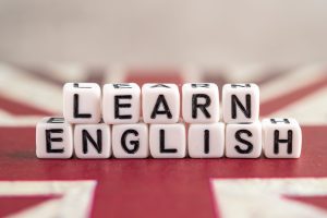 Word Learn English on book with United Kingdom flag, learning English language courses concept.