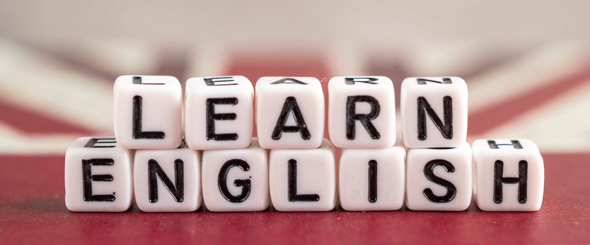 Word Learn English on book with United Kingdom flag, learning English language courses concept.
